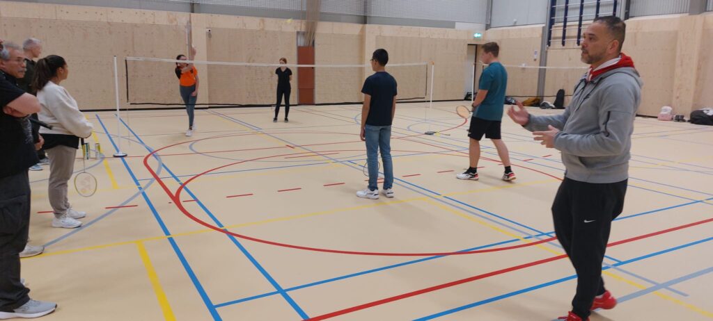 Trainer Rafaël geeft tijdens een dubbelspel demonstratie met vier jeugdspelers uitleg aan de ouders over coaching.