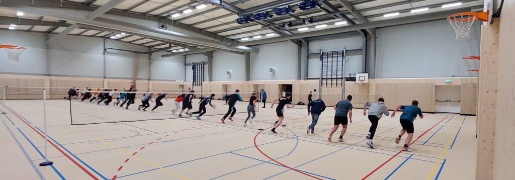 De ouders en jeugdleden rennen over het veld voor de warming up.